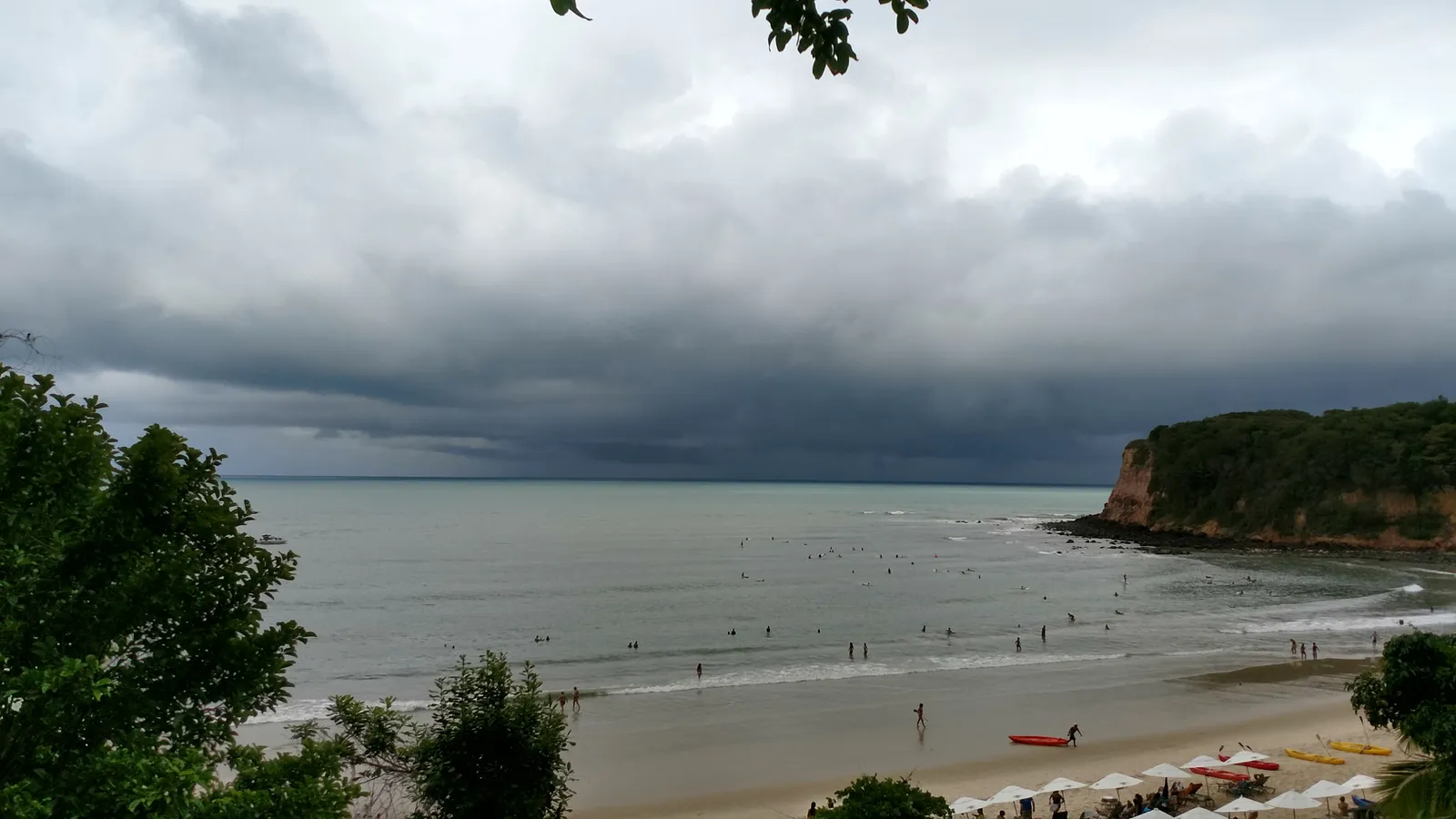 Vista do alto de uma praia do Rio Grande do Norte, com falésias e mar esverdeado.